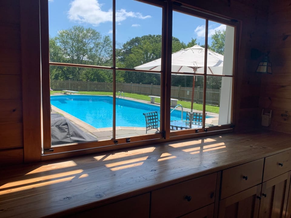 The windows swing in and hook to create a serving counter from the pool kitchen.