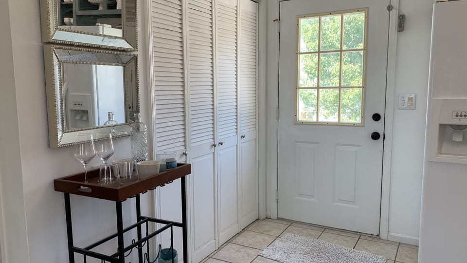 Upstairs back door to small porch with bistro table and chairs overlooking pool
