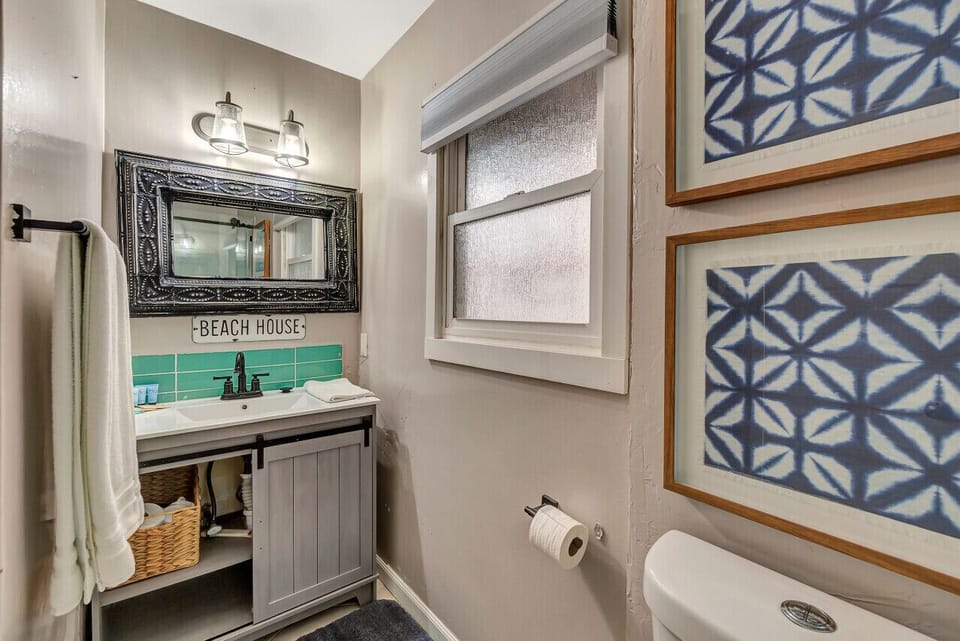 Second full bath w/ turquoise vanity & patterned tile accents.