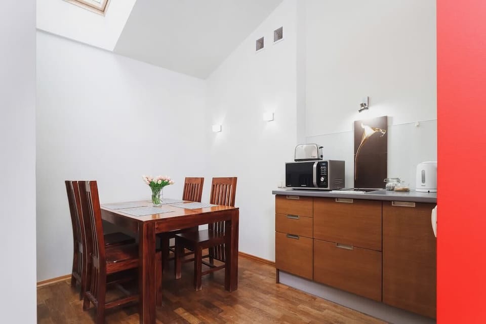 The dining area features a wooden table surrounded by comfortable chairs, providing an intimate setting for meals and gatherings.