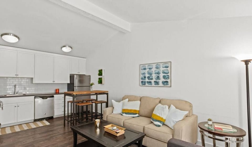 Living room with sleeper sofa and smart TV open to the kitchen