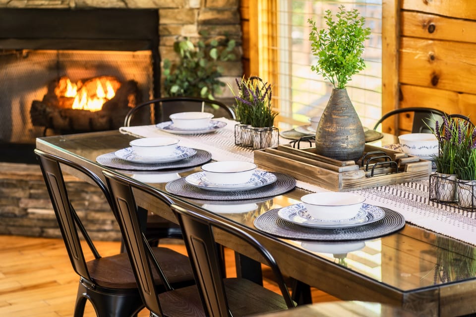 The dining table showcases a wooden base topped with sleek glass good for 8.