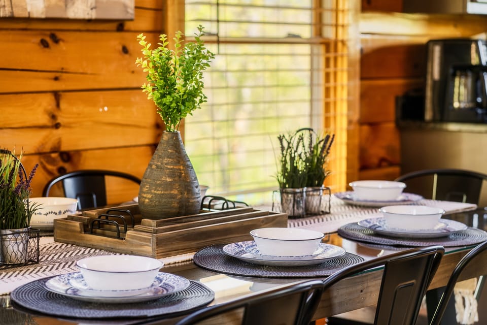 The dining table showcases a wooden base topped with sleek glass.
