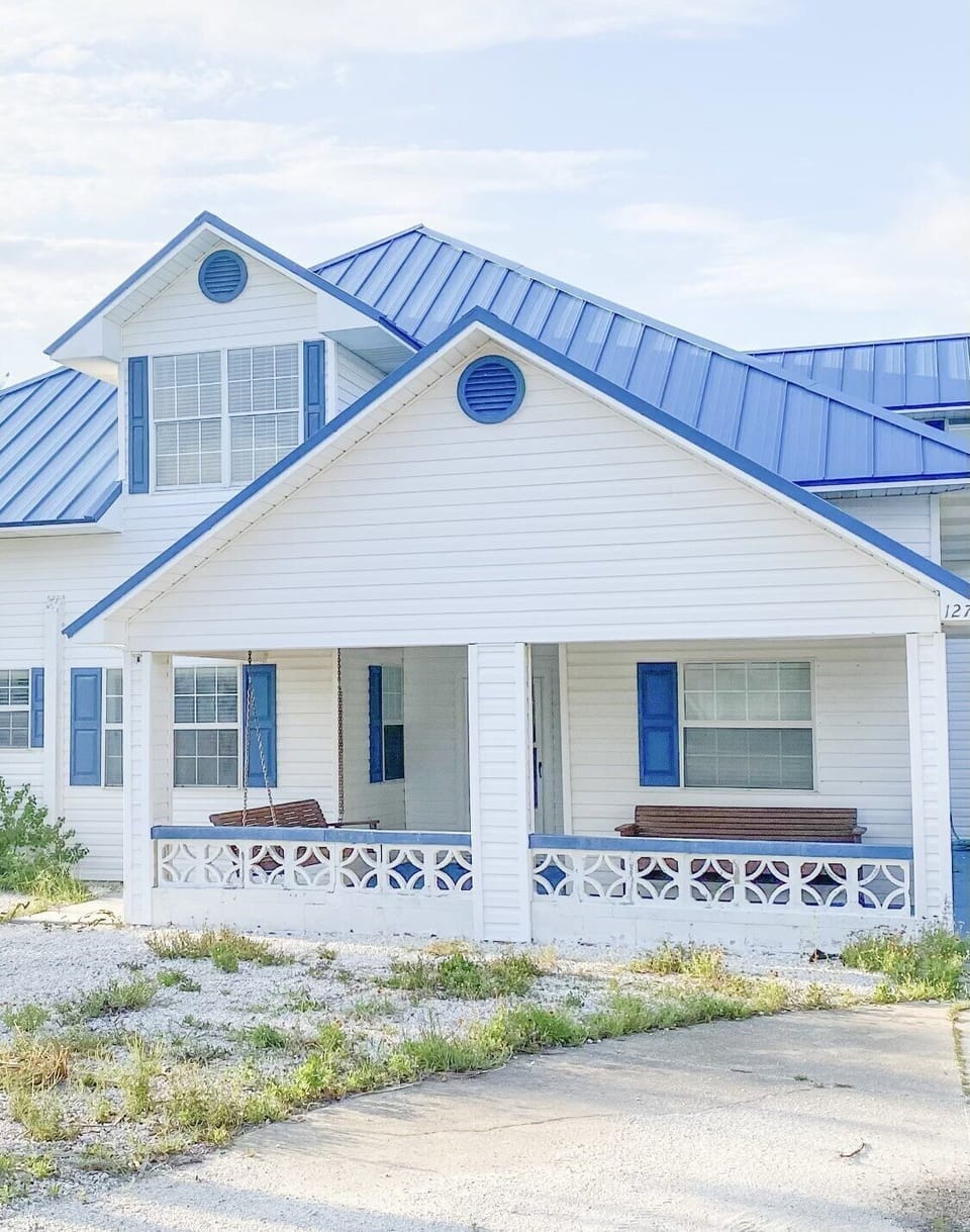 Front of house with porch swing and bench 