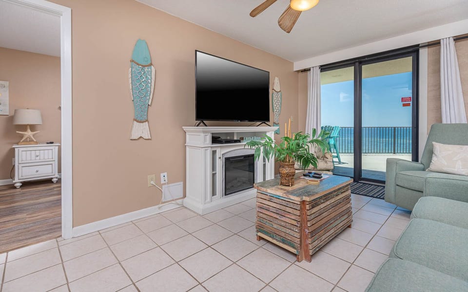 This inviting living area features a large TV, cozy seating, queen sofa-sleeper, and a breathtaking view from the balcony