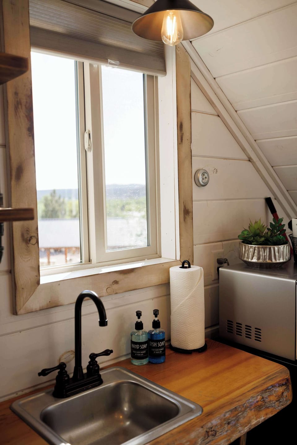 Treetop kitchenette with kitchenware, utensils, hot plate, microwave, mini fridge, and coffee essentials for easy meals and snacks during your stay.