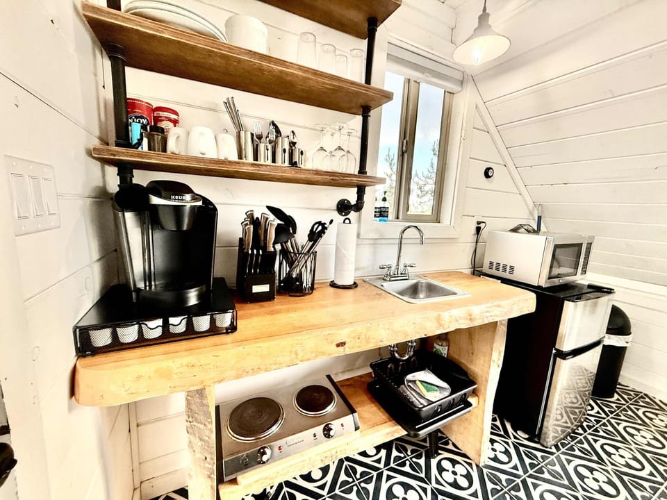 Well-stocked kitchenette inside your Treetop cabin with a Keurig, dishes, glassware, utensils, cookware, and essentials for simple meals during your Southern Utah stay.