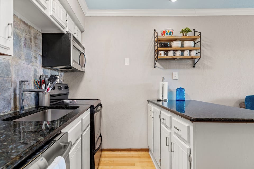 Pretty kitchen with full size appliances and large sink.