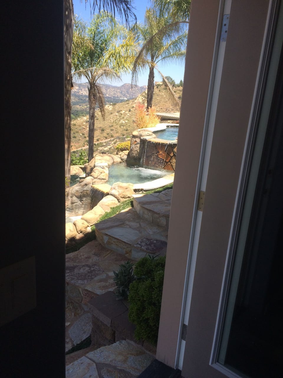 view out the guest house door to the waterfall-lagoon pool