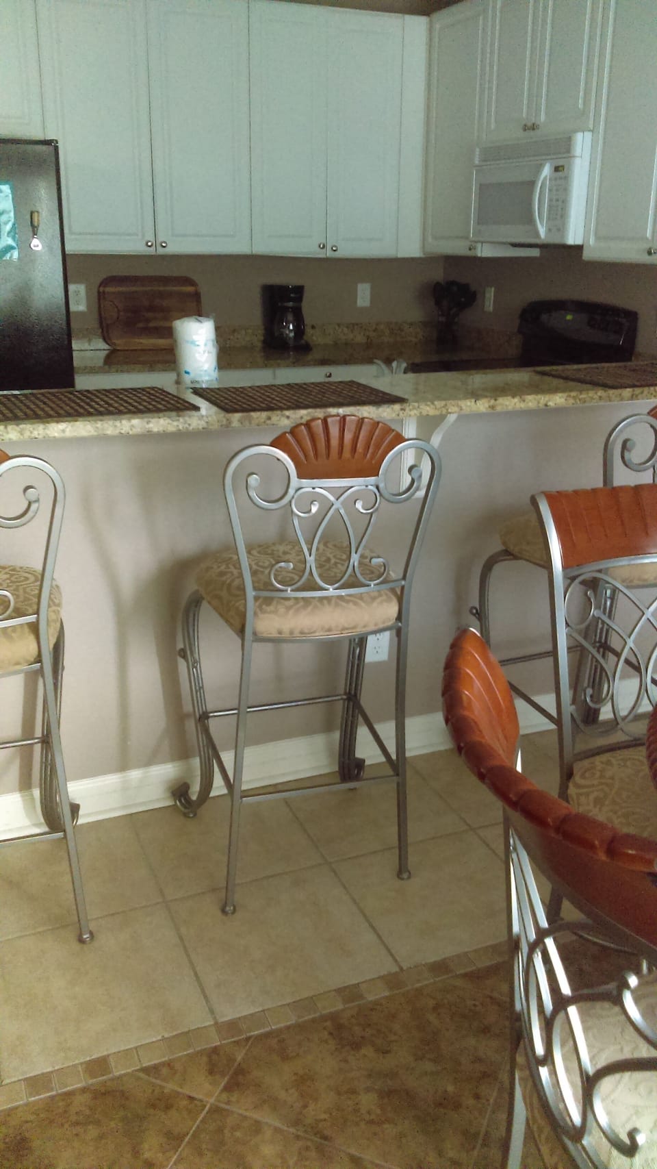 Dining thru to Kitchen with Tile floors.  4 Dining Chairs and 4 Bar Stools.