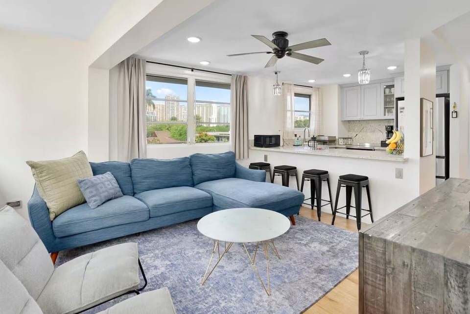 Open-plan living with Waikīkī city views & breakfast bar seating for four.