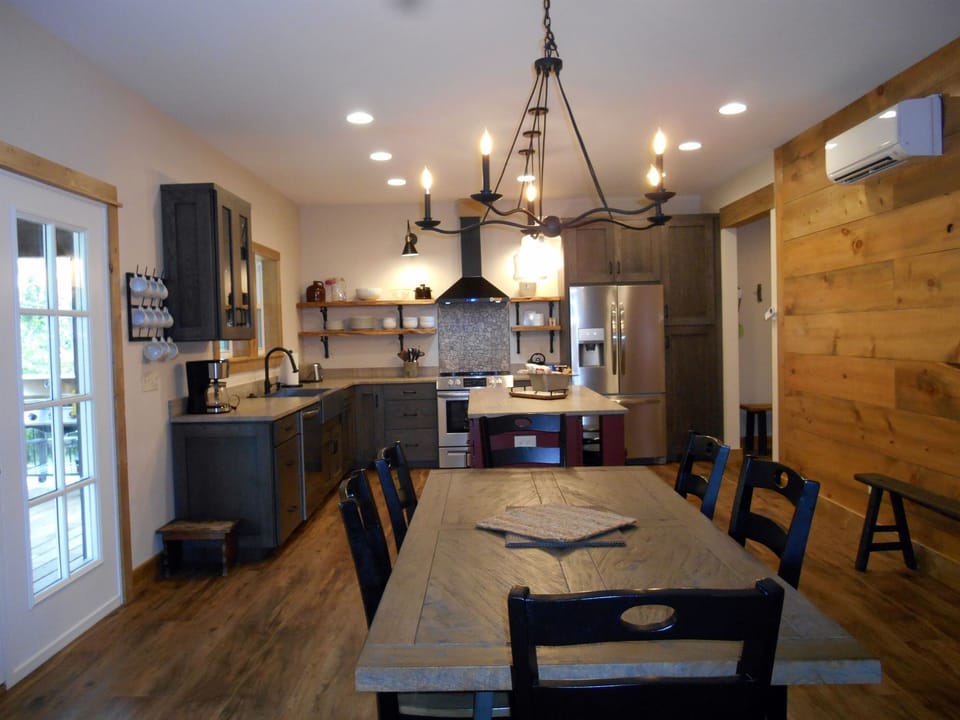 dining and kitchen all flow with a door out to the deck to grill