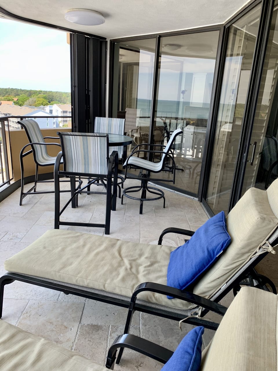 Main balcony with 2 cushioned chaise lounges, table with 4 chairs and ocean view