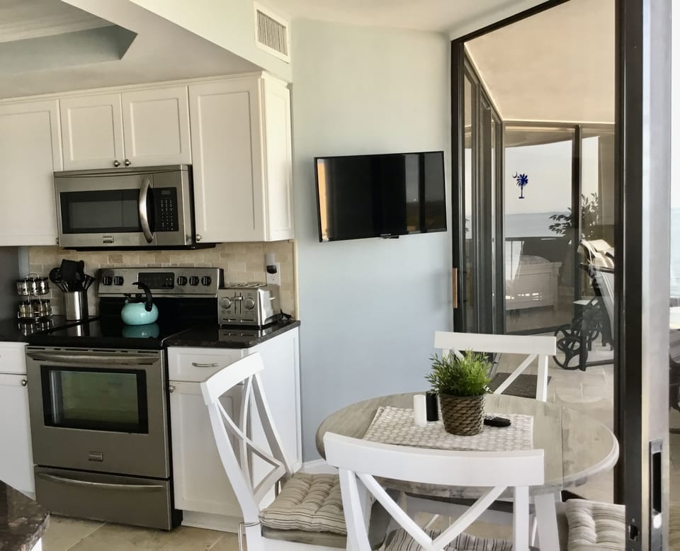Eating area in kitchen with flat screen TV mounted on wall