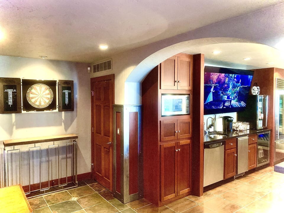 Real Dart Board with real darts next to bar and movie theater.
