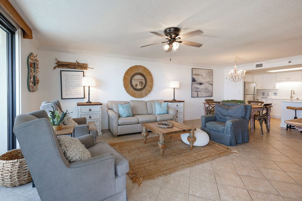 Bright living area featuring a cozy sofa with queen sleeper, accent chairs, and a dining space, all with a welcoming vibe