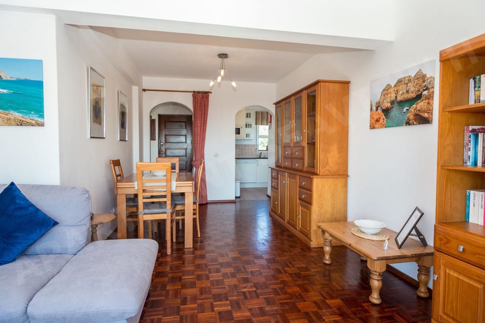 Open-plan dining area in Seaview Apartment H with sea views through the window, connecting to the bright living room, perfect for family meals on holiday in Praia da Luz