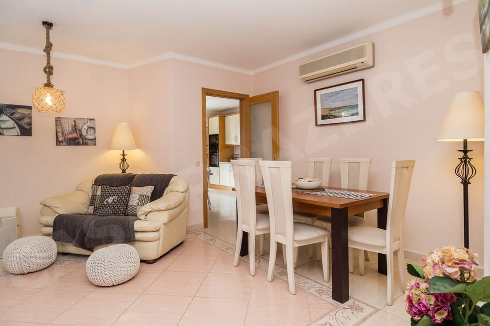 Open-plan dining area at Casa Prazeres holiday villa in Carvoeiro, Algarve, with stylish dining table and seating, connecting to the comfortable living room and kitchen areas
