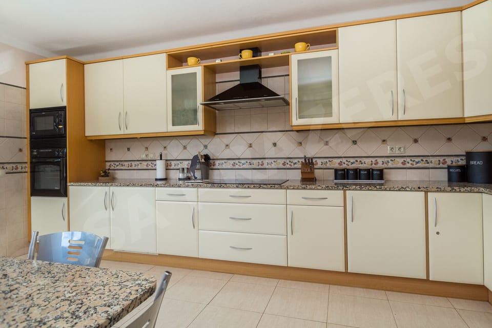 Fully equipped kitchen at Casa Prazeres holiday villa in Carvoeiro, Algarve, with modern appliances, granite countertops, and ample storage for self-catering holidays