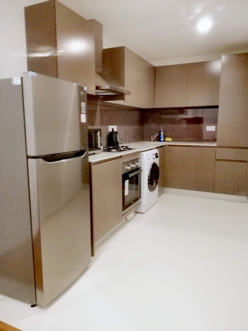The kitchen which has a refrigerator, stove, and oven. 