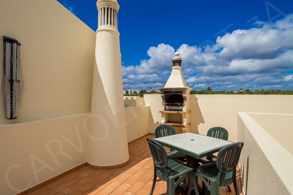 Private terrace with outdoor dining area and views of the resort surroundings at Carvoeiro Apartment 7A, Algarve