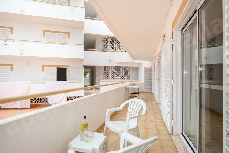 Private balcony at Apartment Amalia in Carvoeiro, with outdoor seating overlooking the apartment complex courtyard, ideal for relaxing and enjoying the Algarve sunshine