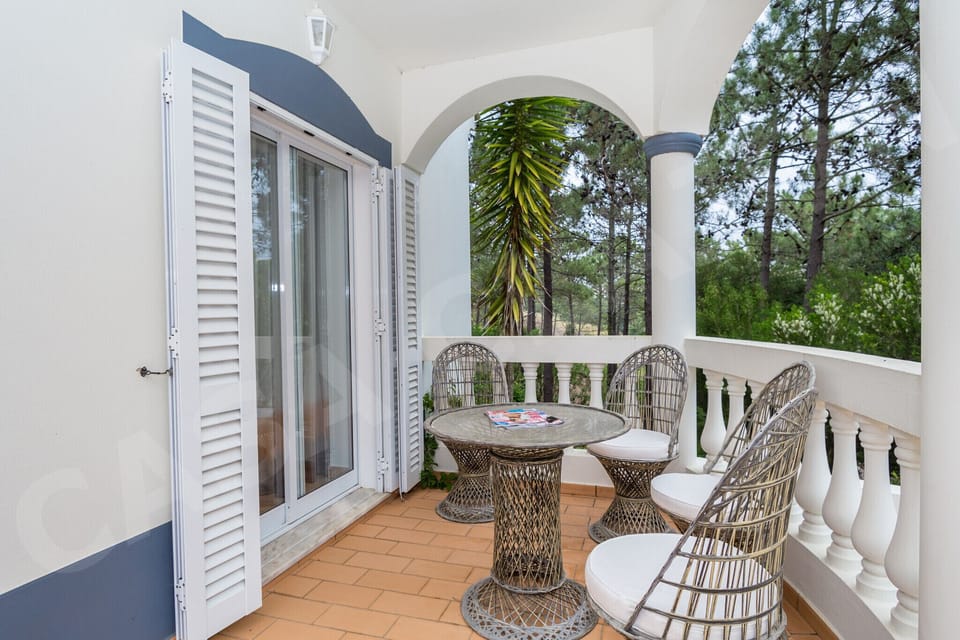 Bird's-eye view of the spacious pool terrace at Casa Clajon, with its kidney-shaped heated pool and sun loungers, in Parque da Floresta, Budens.