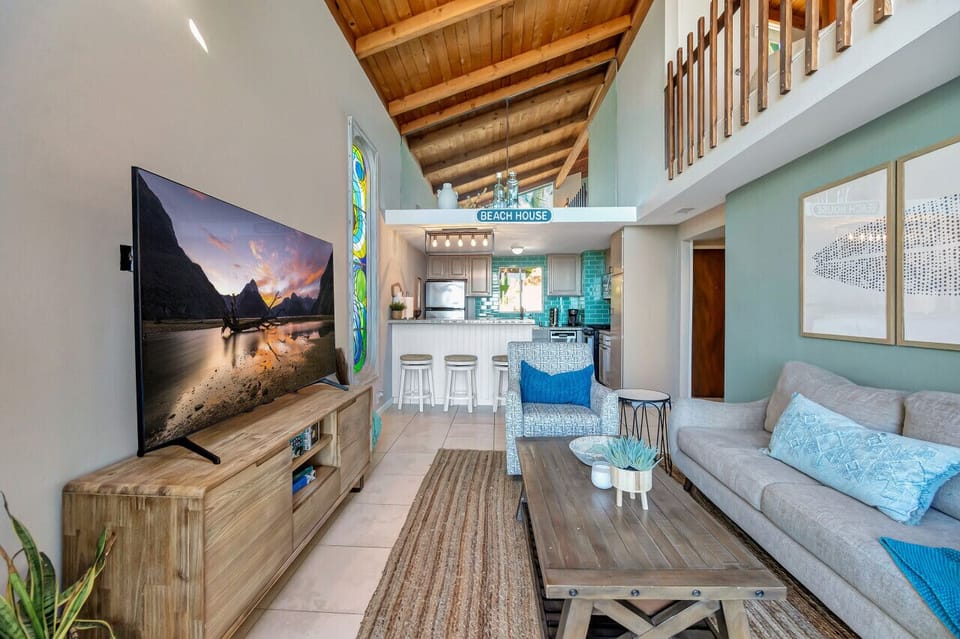 Coastal-inspired living area w/ comfy sofa, TV & open flow to the kitchen.