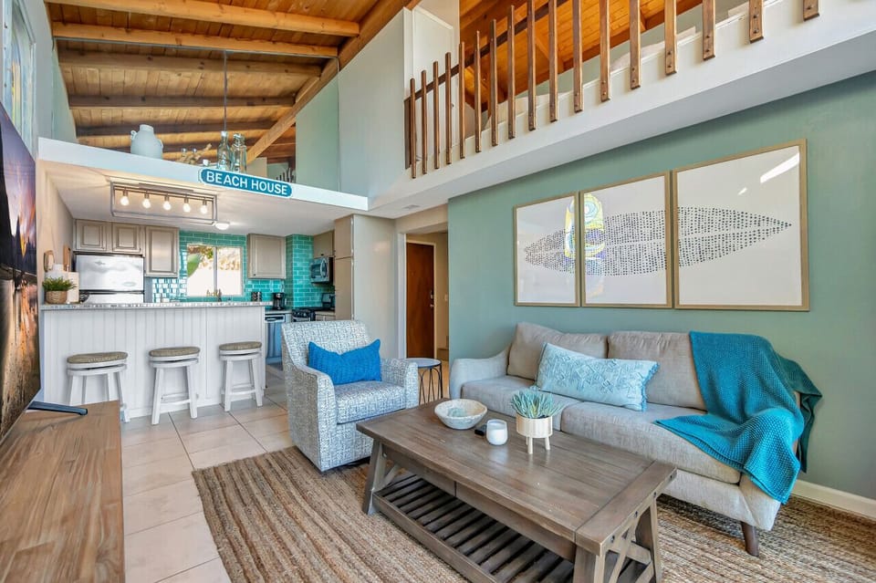 Rustic wood beams & airy loft accents add warmth to the bright living room.