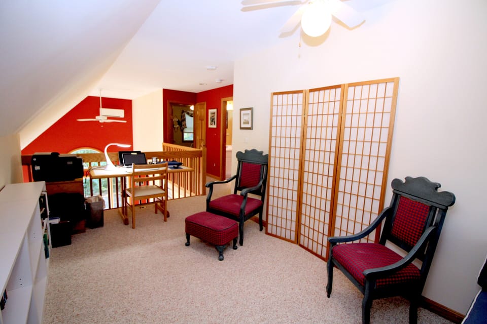 Second floor loft den with sofa and desk