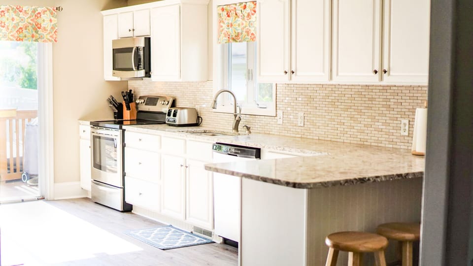 Remodeled kitchen has stunning quartz countertops and stainless steel appliances