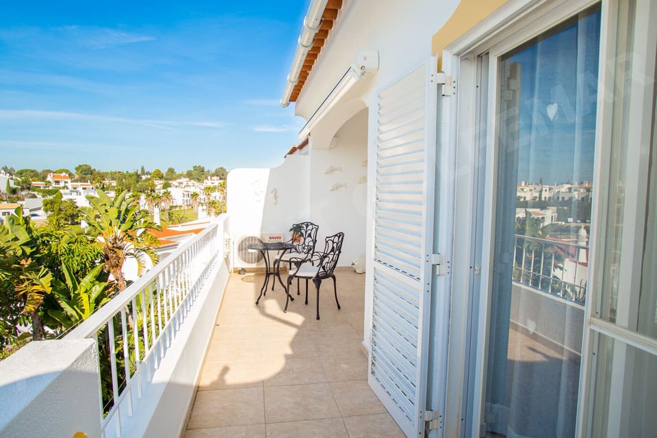 Private balcony at Vila Golfemar apartment with views over the beautifully landscaped resort gardens, communal pool, and surrounding Algarve countryside, perfect for morning coffee or evening relaxation