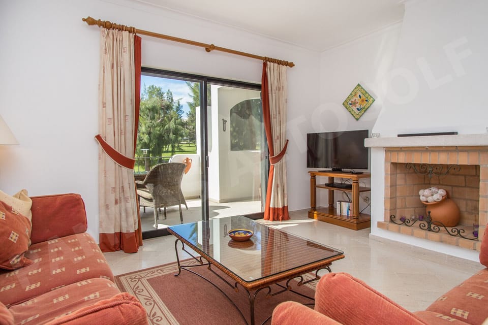 Spacious living room at Apartment Pampas with soft furnishings, large windows letting in natural light, and views of the surrounding gardens, ideal for relaxing after a day exploring Alvor and Praia da Rocha