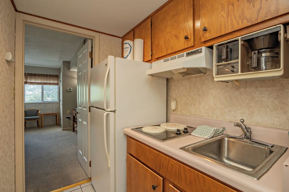 Your fully equipped kitchen features everything needed to prepare home-cooked meals during your stay, with a spacious refrigerator, electric stove, microwave, and ample counter space.