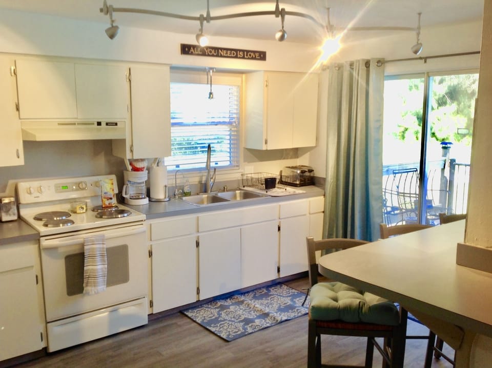 Kitchen with coffee maker, toaster, microwave, and bar seating for 4