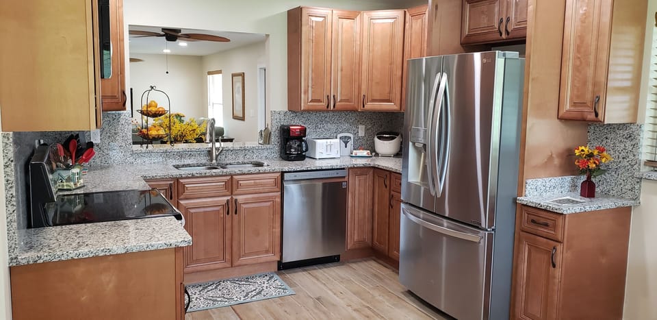 Kitchen with all, stainless steel appliances and pass thru window to dining area