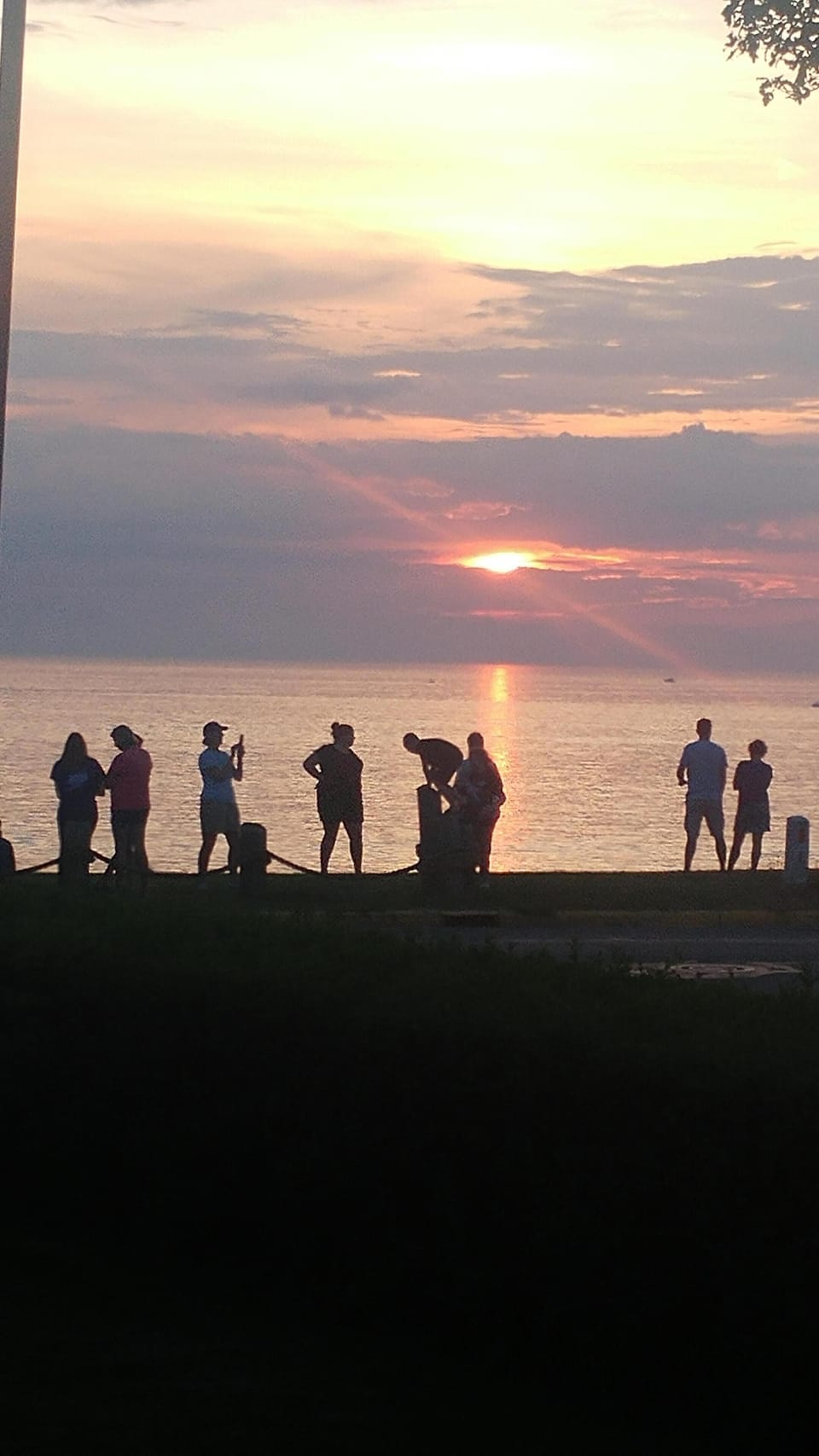 The crowd gathers for sunset on the crest across the street.