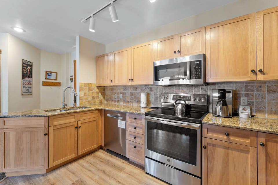 Full kitchen featuring granite countertops and stainless steel appliances.