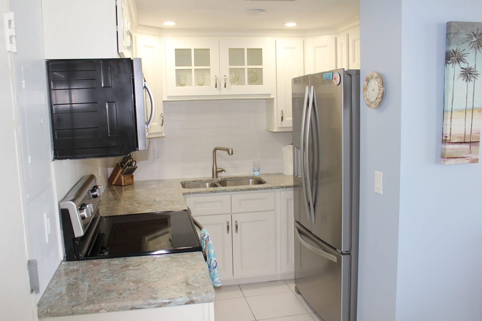 Newly remodeled kitchen with quartz countertop and sparkling tile backsplash