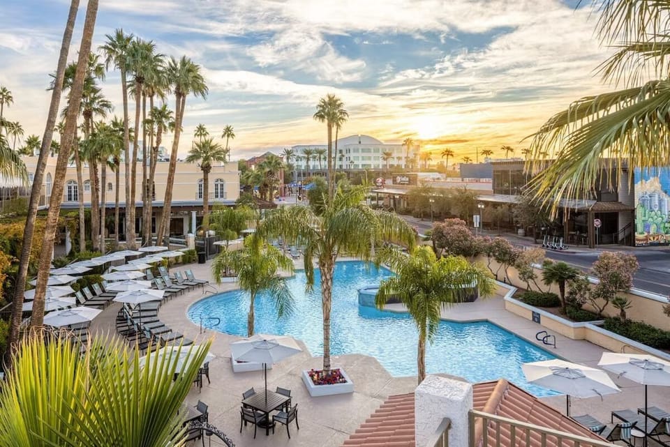 Unwind at sunset beside the sparkling resort pool oasis.