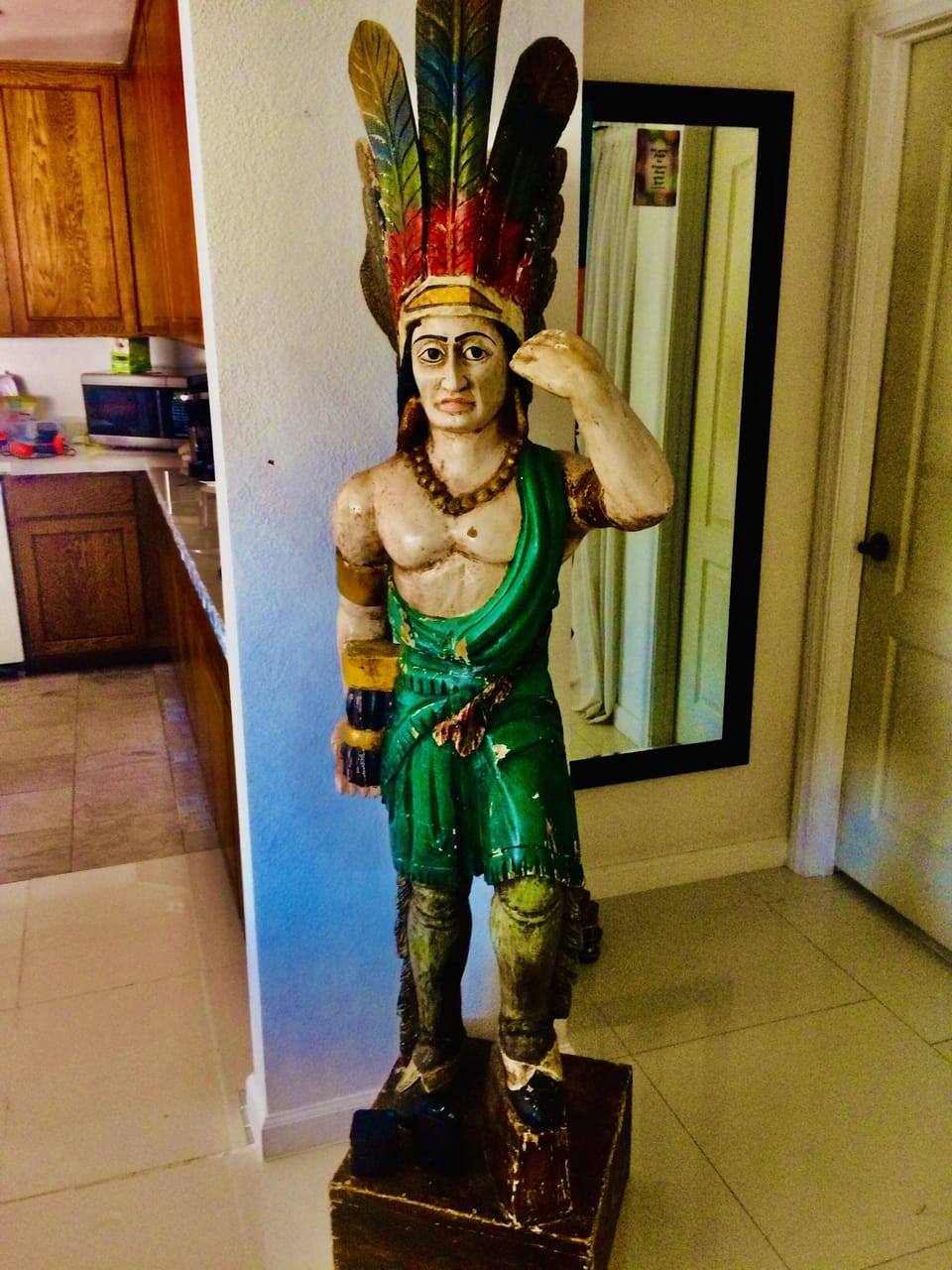 Hau is standing in entry to greet guest. He is a 1800 Cigar Store carved Indian 