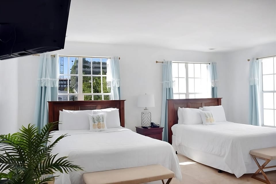 Stretch out in crisp linens beneath sunlit, beachy windows.