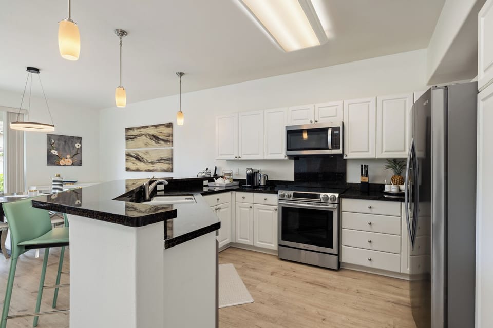kitchen showing stove microwabe, fidge and sink. 