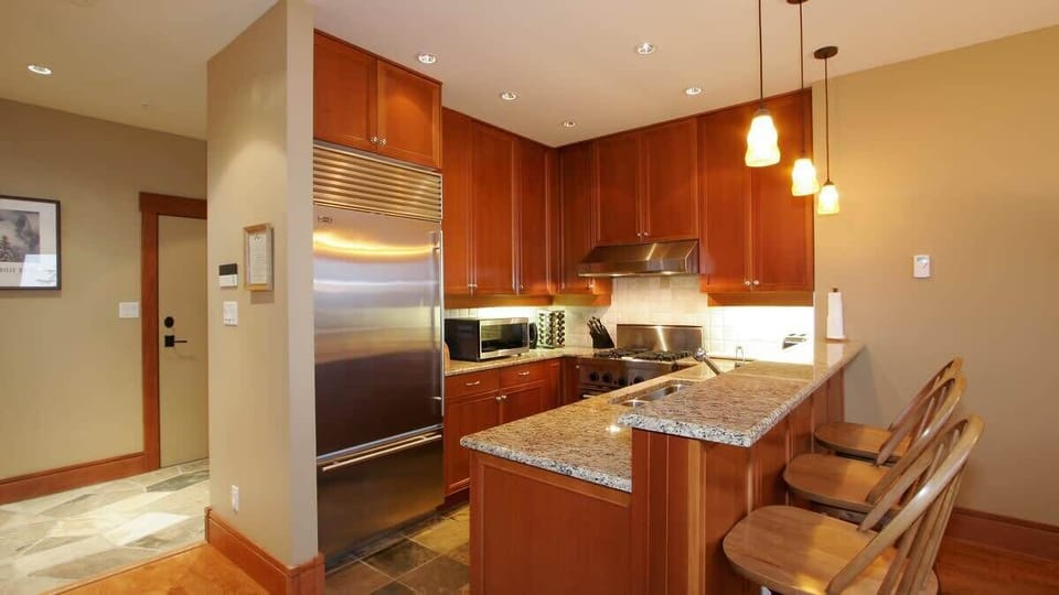 - Modern kitchen with stainless steel appliances and polished granite countertops  
- Warm wooden cabinetry and bar seating create a functional cooking space  
- Perfect for preparing hearty meals after exploring the mountain trails  
