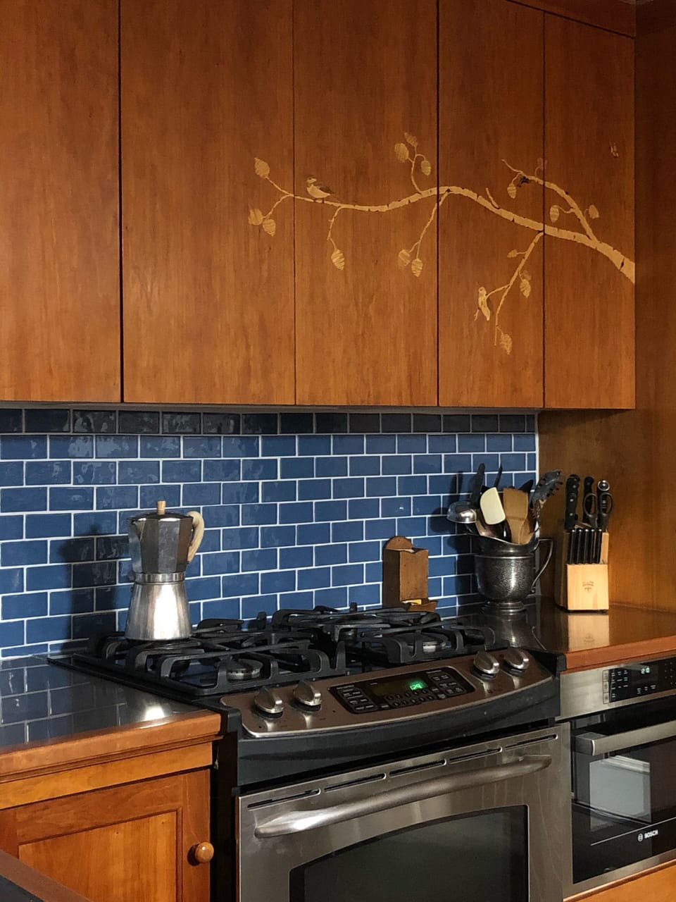 Custom cherry cabinets with inlay of birch trees, chickadees, and more.