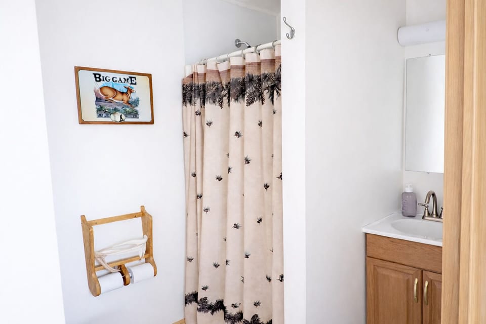 Full bathroom with walk-in shower and rustic lodge touches at Pond View Loft.