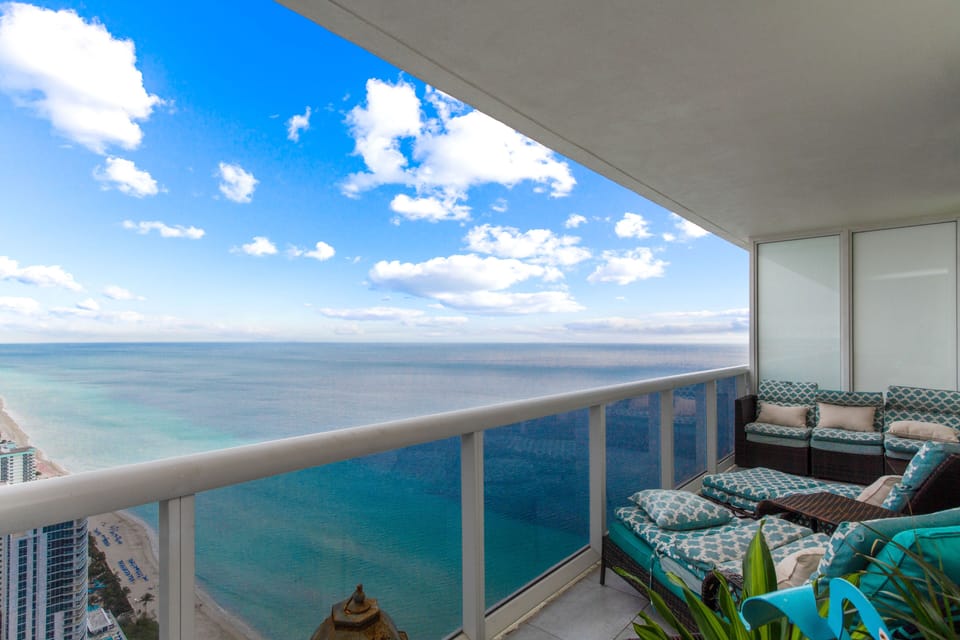Two chaise lounges overlooking ocean and beach.  Additional seating far end.