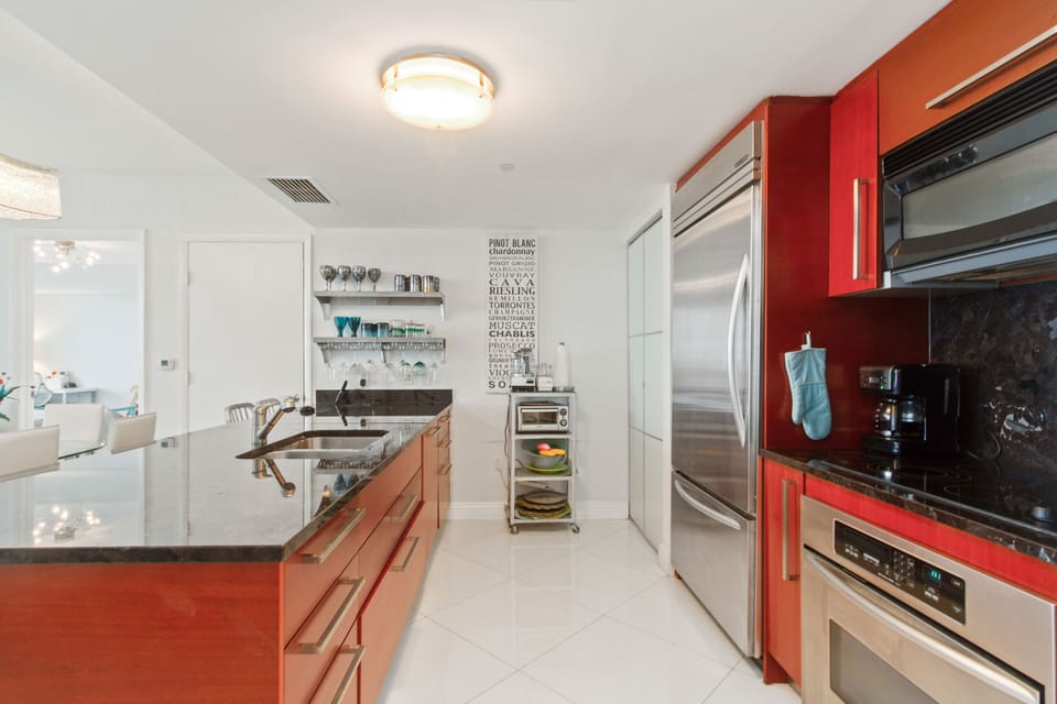Full view of kitchen galley.  Stove, microwave on right, with frig. dishwasher