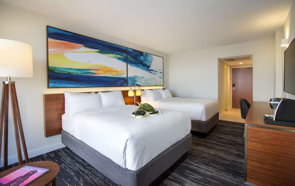 Stretch out on crisp linens beneath bold, modern coastal artwork.