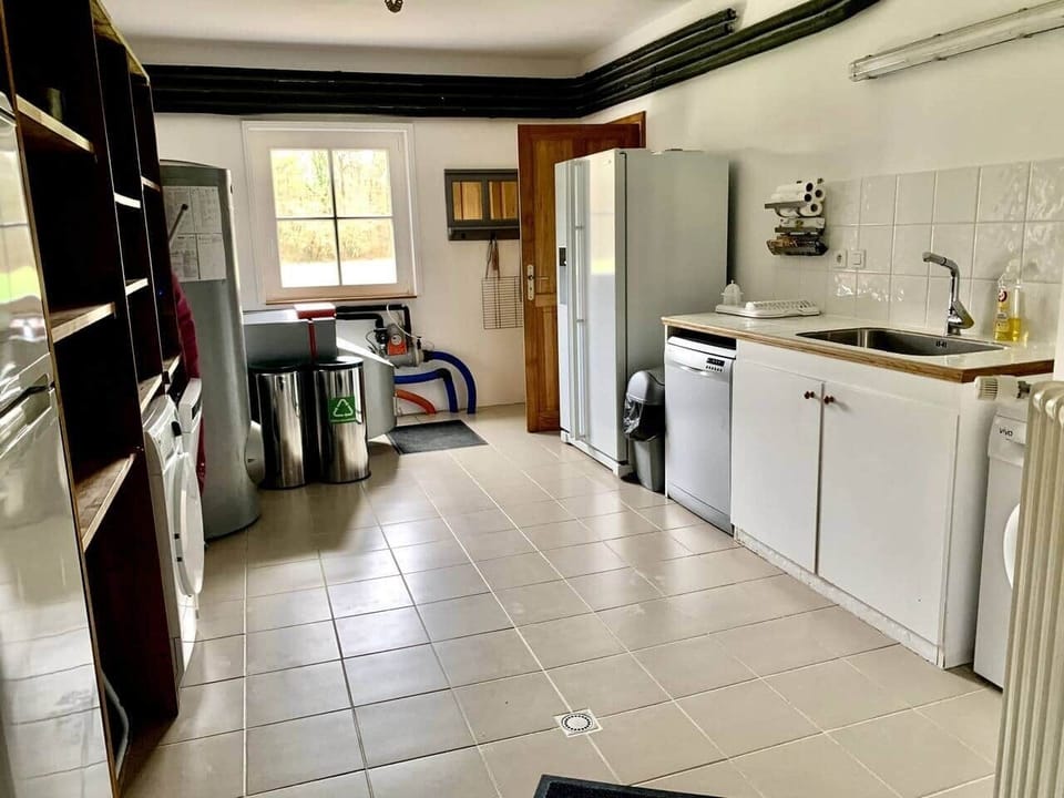Arrière cuisine : chaudière, bacs pour tris sélectif, 2 machine à laver la vaisselle, 1 machine à glaçons, 1 sèche linge, 2 frigos avec congélateur, 1 machine à laver le linge, 1 grand évier, 1 poubelle tout venant, étagères de rangement, 